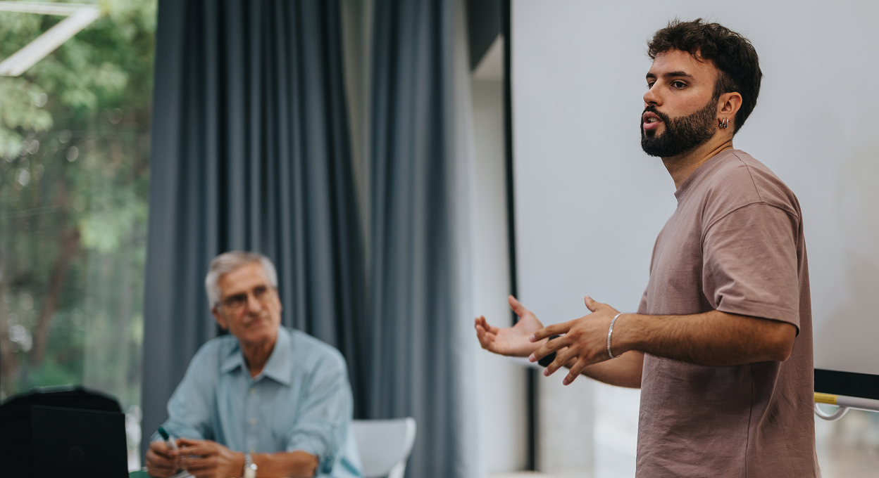 A speaker presenting to colleagues in a meeting room